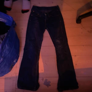 Mörkblå jeans från Levi's - Säljer ett par mörkblå jeans från Levi's med klassisk design. De har en bootcut-stil och är lågmidjade. Perfekta för en avslappnad look.
