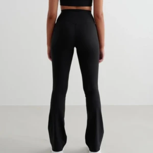 Svarta bootcut leggings - Snygga svarta leggings med bootcut-stil och hög midja. Perfekta för en stilren look och bekväma att bära. Passar bra till både träning och vardag. Använda max 3 gånger så inga täcken på användning. Nypris 800kr