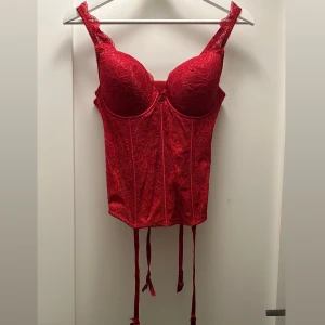 Korsett - Röd spets korsett i storlek B80 (kupa). Aldrig använd med prislappen kvar. Man kan justera även korsetten. Original pris 399 