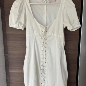 Vit student klänning  - Säljer en vit klänning med en snörnings detalj, skulle passa perfekt som en studentklänning men även fin sommarklänning prislapp sitter kvar, den är inte använd någon gång.🥰 våga fråga om bild på klänning❤️