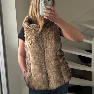 Brun pälsväst från ONLY - Säljer en snygg brun pälsväst från ONLY med rymlig huva. Snygg nu till våren när man inte vill ha jacka ⭐️⭐️