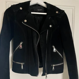 Svart mockajacka från Vero Moda - Jättesnygg svart mockajacka från Vero Moda med dragkedjor och knappar i silver, stl XS! 