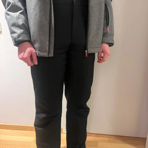 Svarta täckbyxor från ski industries - Säljer snygga svarta täckbyxor perfekta för vintern och som skidkläder.✨ De har hängslen och fickor, dragkedja längst fram. Det finns inga defekter och är i storlek XS, men passar även dig i S. Kom gärna med prisförslag och frågor!🌟
