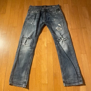 Blåa Replay jeans - Replay jeans med snygga slitningar. Storlek 33/32