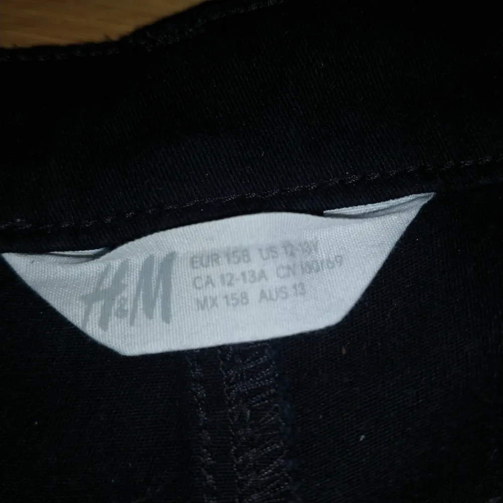 Snygga svarta shorts från H&M med klassisk design. De har en dragkedja och knapp framtill samt fickor både fram och bak. Perfekta för en avslappnad stil.. Shortsit.