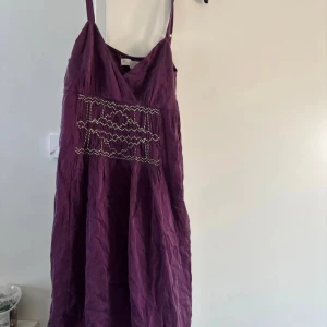 Lila klänning från Odd Molly - Säljer en lila klänning från Odd Molly med smala axelband och v-ringning. Klänningen har ett dekorativt mönster framtill och en avslappnad passform. Perfekt för sommarens varma dagar! Storlek S