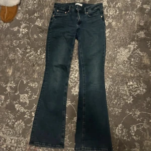Blå bootcut jeans - Snygga svarta bootcut jeans med klassisk design. De har en lågmidjad passform och är perfekta för en avslappnad stil. Jeansen har fem fickor och knappar framtill.