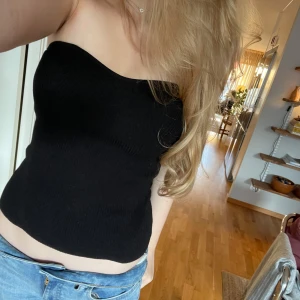 Svart ribbad bandeautopp - Säljer en jättesöt bandeautopp ifrån Gina. Den har en liten ringning vid bysten och sitter tajt imot kroppen. Den är i Stl M men den sitter mer som en S så den är alltså ganska så liten i storleken. Den är ribbad i materialet! Pris kan diskuteras!❤️