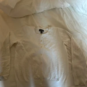 Vit kofta från Ralph Lauren - Säljer en söt vit kofta från Ralph Lauren med små prickar och knappar framtill. Jag säljer den för jag inte har nån användning för den längre❤️ 