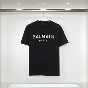 Svart t-shirt från Balmain - Snygg svart t-shirt från Balmain med guldtryck 'BALMAIN PARIS' på framsidan. Perfekt för en stilren look. Tröjan finns i 3 exemplar i storlek M!