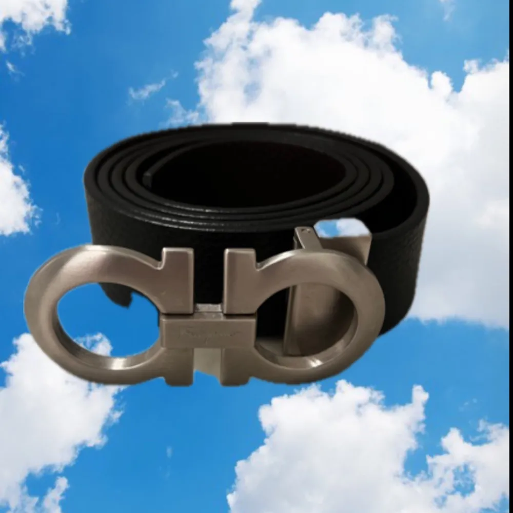 Snyggt svart bälte från Ferragamo med ett stilrent silverfärgat spänne i metall. Perfekt för att ge en elegant touch till din outfit. Tillverkat i Italien.. Muu.