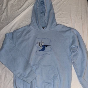 Ljusblå hoodie med tryck - Säljer en ljusblå hoodie med en cool design på framsidan och texten 'WHATEVER YOU LOST WASN'T YOURS' på baksidan