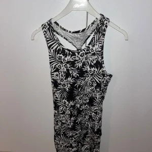 Sommarklänning - Snygg svartvit klänning från Ellos med blommigt mönster. Den är ärmlös och har en cool ryggdesign. Perfekt för sommarens alla tillfällen! Skriv för fler bilder 