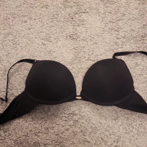 Svart bhl från Censored - Snygg svart bh från Censored i storlek A70, med vadderade kupor och justerbara axelband. Perfekt om du vill ha mycket push up! Den har en liten guldfärgad detalj framtill som ger en extra touch av elegans. Säljer då jag har växt ur den🤍
