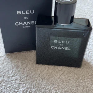 Bleu de Chanel Eau de Toilette - Säljer en elegant och tidlös Bleu de Chanel Eau de Toilette. Flaskan är mörkblå och fyrkantig med en stilren design. Perfekt för den som vill ha en fräsch och maskulin doft.  Har använt ungefär 10-15ml. Pris kan diskuteras, köpt för 1900kr.