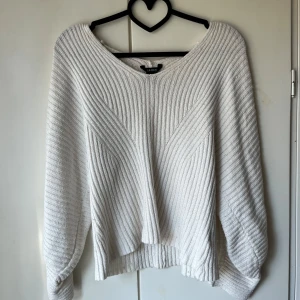 Vit stickad tröja från Lindex - Säljer en vit stickad tröja från Lindex med v-ringad hals och ribbad struktur. Tröjan har tre kvarts ärm och en lite lösare passform. Superenkel att matcha till olika outfits! Har bara använt den 2 gånger.