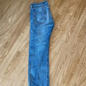 Levi's 501 blå jeans W32 L32 - Klassiska blå Levi's 501 jeans med raka ben och knappgylf. Modellen har fem fickor och är tillverkad i slitstarkt bomull. Strl 32 x 32 straight leg