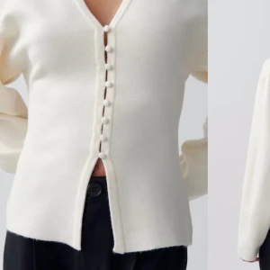 Vit stickad kofta med knappar😍 - Säljer en stilren vit stickad kofta med v-ringning och klädda knappar framtill. Koftan har lång ärm och rak passform,.