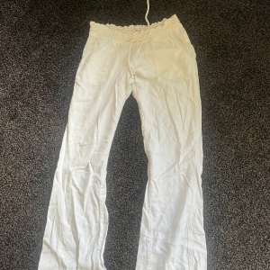 Vita linnebyxor från Roxy med dragsko - Säljer ett par vita linnebyxor från Roxy med elastisk midja och dragsko. Byxorna har raka ben, fickor fram och bak.🌸 Strl M. Säljer även ett par likadana fast mörkblå🥰
