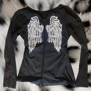 Super cool tröja‼️‼️ - Super snygg tröja ifrån yuxuan fashion med vingar på baksidan och ett coolt kors med vingar, silvriga döskallar och nitar på framsidan❤️det står den är storlek L men den sitter mer som en S eller XS