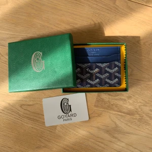 Mörkblå Korthållare - Säljer en riktigt snygg mörkblå korthållare. Den är helt ny och kommer med originalboxen. Perfekt för dig som vill få plats med dina kort samtidigt som du gör det i stil. Vid frågor eller funderingar skicka ett pm, Mvh