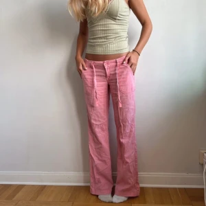 Rosa linnebyxor med snörning - Säljer ett par rosa linnebyxor med raka ben och snörning i midjan. Perfekta för en trendig och avslappnad stil. Förra ägarens bilder men för stora på mig