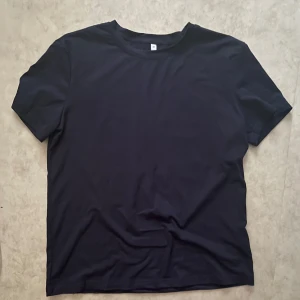 Mörkblå t-shirt med tryck Faith Over Fear - Mörkblå t-shirt i bomull med vit text på ryggen: 'Faith Over Fear' och bibelcitat. Klassisk rund hals och korta ärmar. Perfekt för dig som vill ha ett statement-plagg med budskap. Passar även storlek S & M. Stor för att vara XS. Aldrig använt🩷