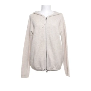 Beige stickad hoodie med dragkedja - Mysig beige stickad hoodie med dragkedja framtill och huva. Tröjan har långa ärmar och ribbade muddar samt dragsko nertill för en justerbar passform. Perfekt för lager-på-lager och chill dagar.