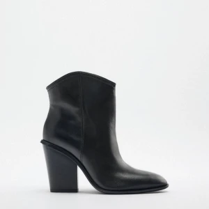 Svarta boots med klack - Säljer ett par svarta boots i skinn med hög klack och spetsig tå. Snygg minimalistisk design som passar perfekt till många olika outfits. Skorna har en klassisk siluett och är tillverkade i slätt material.