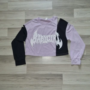 Lila och svart croppad långärmad tröja från Romwe - Säljer en cool croppad långärmad tröja från Romwe i lila och svart med BABYGIRL-tryck framtill. Tröjan har en unik tvåfärgad design och är perfekt för dig som vill sticka ut. Mjuk bomullskänsla och relaxed fit.