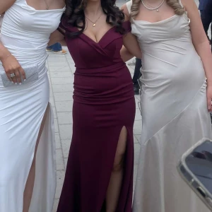 Balklänning vinröd  - Säljer en elegant vinröd långklänning med djup v-ringning och markerad midja. Klänningen har en hög slits framtill och är ärmlös. Säljer den eftersom jag bara hade användning till den på balen. Pris kan diskuteras💋