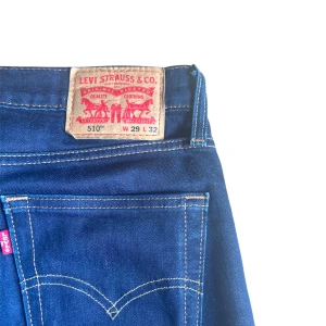 Levi's 510 blå jeans - Säljer ett par klassiska blå Levi's 510 jeans med smal passform. Jeansen har fem fickor, dragkedja och knapp i midjan samt tydliga kontrastsömmar. Storlek W29 L32. Perfekta för dig som gillar en skinny stil.
