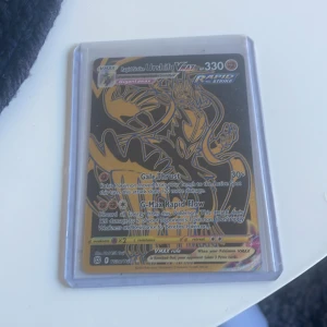 Pokémonkort Rapid Strike Urshifu VMAX - Säljer ett Pokémonkort: Rapid Strike Urshifu VMAX med 330 HP. Kortet har en svart och gul design med holografiska detaljer och är inplastat i ett skyddsfodral. Perfekt för samlare eller Pokémon-entusiaster!