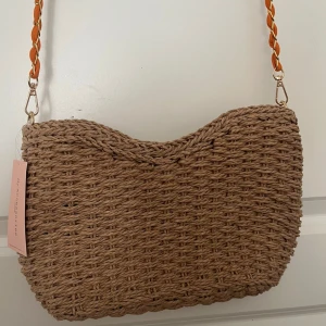 Strå-väska  - Säljer denna somriga väska från Asos. Långt band och magnetknapps-stängning. Fack på insidan. Aldrig använd, prislapp är kvar. Nypris 300 kr. Hör gärna av er för fler bilder eller frågor. Priset kan diskuteras. 