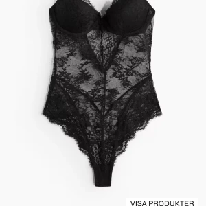 Svart spetsig body - Säljer en svart body i spets med vadderade kupor och justerbara axelband. ! Aldrig använd ! För stor för mig i ryggen och midjan. Den hade inga lappar på när den köptes då gick den tyvärr inte heller att lämna tillbaka❤️❤️Testa att pruta!!!