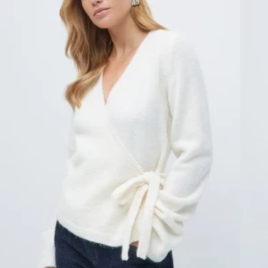 Vit omlottkofta med rosett - Säljer en supermjuk vit omlottkofta med v-ringning och knytband i sidan som bildar en söt rosett. Skriv för fler bilder❤️kommer från ginatricot❤️ inte min bild, nypris: 400 kr