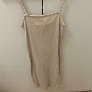 Beige ribbad klänning - Säljer en stilren beige ribbad klänning med smala axelband. Nyskick