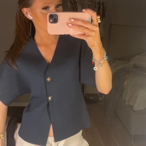 Mörkblå kortärmad blus med knappar - Snygg mörkblå blus/tröja med korta ärmar och stilrena knappar framtill. Passar bra till både jeans och kjol. Säljer pga att den inte används 💕💕 skriv för fler bilder 🙌🏻