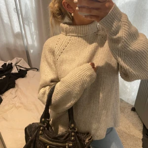 Beige stickad polotröja - Säljer en mysig beige stickad polotröja med ribbade detaljer. Perfekt för kyliga dagar med sin höga krage och långa ärmar. En stilren och bekväm tröja som passar till det mesta🤎🤎