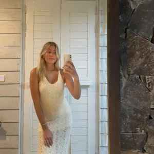 Vit spetsklänning - Fin virkad klänning med en underklänning så att den blir ”genomskinlig” från den och neråt. Perfekt som strandklänning men går också att klä upp!🌸