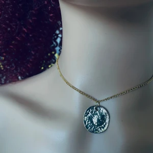 By prisförslag- Guldhalsband med rund berlock - Elegant guldhalsband med en rund, texturerad berlock. Kedjan är tunn och smidig, vilket ger en stilren look. Perfekt för att lägga till en touch av elegans till din outfit.