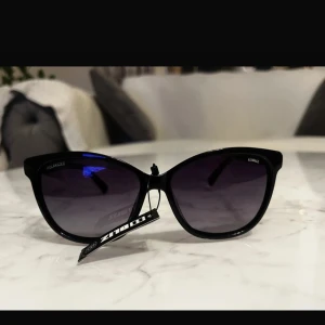 Svarta solglasögon från Bliz - Snygga svarta solglasögon från Bliz med polariserade linser. Perfekta för soliga dagar och ger ett stilrent intryck. De har en klassisk form som passar de flesta ansikten.