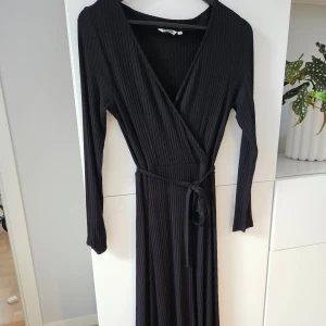 Omlottklänning Indiska  - Stretchig, ribbad omlottklänning från lndiska, Använd en gång. Storlek S.