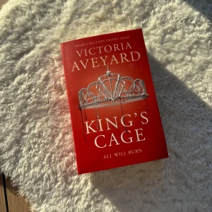 King's Cage - Säljer boken 'King's Cage' av Victoria Aveyard. Den har en röd omslagsdesign med en krona i silver. Boken är en del av serien 'Red Queen' och erbjuder en spännande fortsättning på berättelsen om makt och uppror. Perfekt för dig som älskar fantasy och äventyr.❗️SÄLJER ÄVEN FÖRSTA OCH ANDRA 