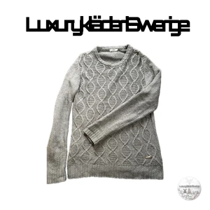 J.Lindeberg Grå tröja - Säljer en stilren grå stickad tröja från J.Lindeberg med ett snyggt kabelstickat mönster. Tröjan har långa ärmar och en rund halsringning. Perfekt för kyligare dagar!