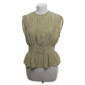 Topp/blus H&M - Säljer en supersnygg blus/topp från H&M med smockdetaljer i midjan och en lätt volang nedtill. Storlek S, knappt använd. Beige/grön färg 🤍