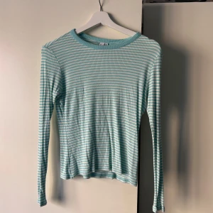 Randig ribbad tröja i ljusblå och vit - Säljer en söt randig tröja i ljusblå och vit. Tröjan är ribbad och har långa ärmar, perfekt för en avslappnad stil. Den är i storlek S och passar bra till både jeans och kjol. Hör av dig vid intresse! 💚