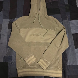 Grön hoodie från Levi's - Säljer en snygg grön hoodie från Levi's med broderad logga på bröstet. Tröjan har en klassisk känguruficka och justerbar huva med dragsko. Perfekt för en avslappnad stil.