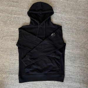 Svart hoodie från Calvin Klein Jeans - Säljer en stilren svart hoodie från Calvin Klein Jeans. Den har en klassisk design med en justerbar huva och en diskret logga på ärmen. Perfekt för en avslappnad look. Storlek S🤙 Kom gärna med offer✌️Fråga om du undrar något!