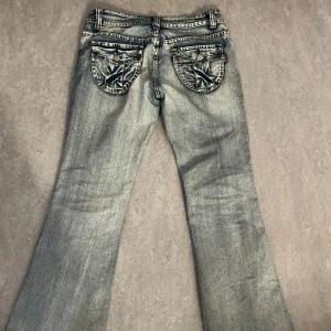 Vintage bootcut jeans  - Snygga blå bootcut jeans från EAX med en cool tvättad look. De har knappar och dragkedja framtill samt unika bakfickor med knappdetaljer. Ungefär 40 tvärs över midjan. De är lågmidjade. Passar mig perfekt som är 160. 